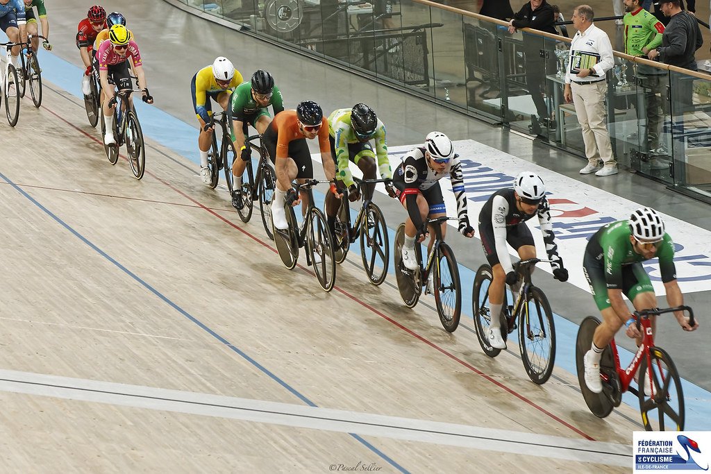 Un peloton dans le virage relevé du Vélodrome National de Saint-Quentin-en-Yvelines